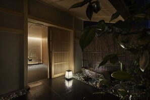 Experience a serene oasis with a sliding door, potted plant, and soothing water feature.