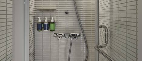 A walk-in shower with a glass door, a handheld showerhead, and a handheld shower hose.