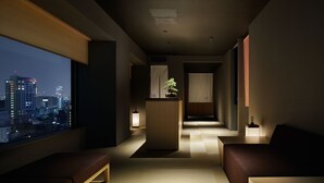 Una habitación de hotel moderna con vista a la ciudad, un área de descanso y una pequeña kitchenette.