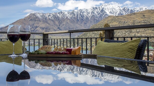 A table with wine glasses and a cheese board, overlooking a mountain range. - Spectacular Views , Large & Modern , Perfect For Families & Large Groups (Queenstown)