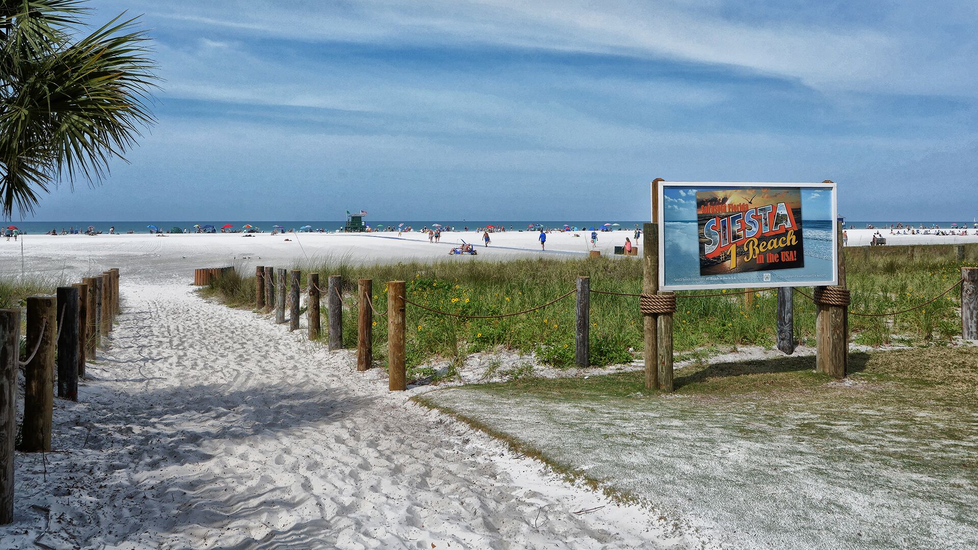 A beach with a sign advertising 'Siesta Beach in the USA'.