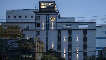 A hotel with a prominent sign reading "Brown-Dot Hotel" and a large illuminated 'B' logo.