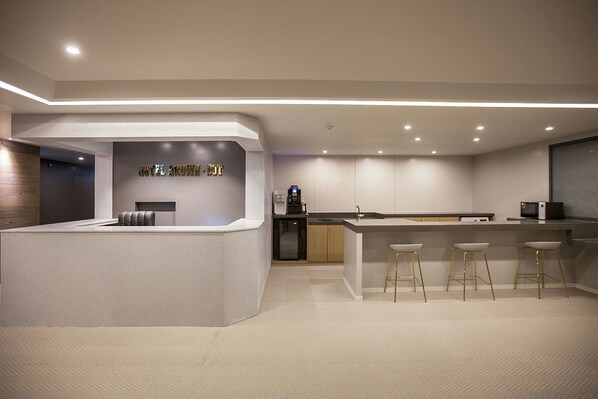 A modern hotel lobby with a reception desk, bar area, and seating. - Browndot Hotel Masan Odong (Changwon)