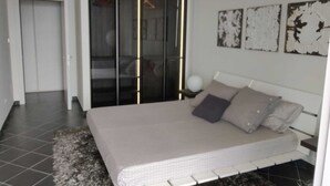 Ein Schlafzimmer mit Bett, Kleiderschrank und Nachttisch.