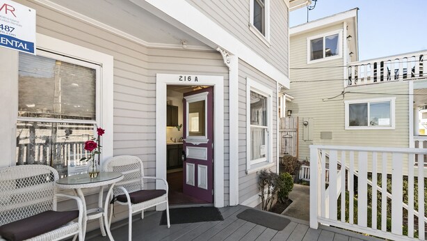 A residential property with a porch, white wicker furniture, a purple door, and a sign indicating rental availability. - 216WA: Budget-friendly Apartment in Victorian Triplex, 2 Blocks to the Beach + W (Avalon)