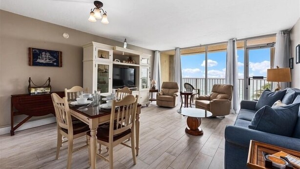 Ein geräumiges Wohnzimmer mit Essbereich, ein Balkon mit Blick und ein Fernseher in der Küchenzeile.