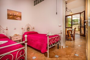 Two beds, a classic metal bed frame, and a serene landscape painting create a peaceful retreat.