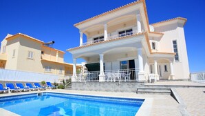 Un bâtiment à deux étages avec une piscine devant.