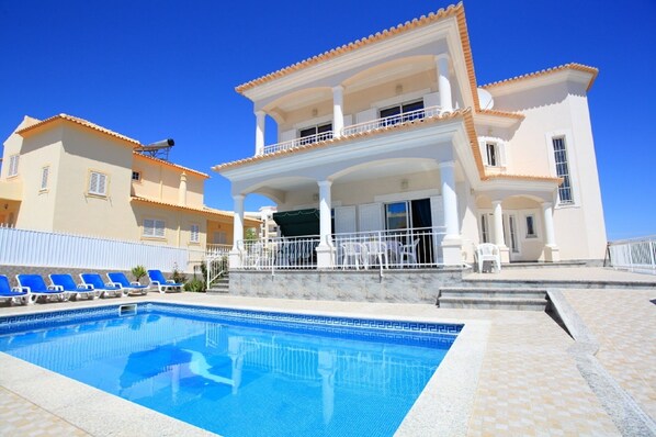 A two-story building with a swimming pool in front.