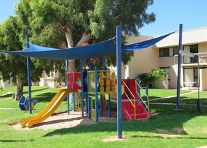 Children can play on the playground with a slide and climbing structure.