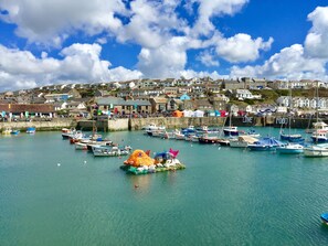 A harbor with boats, a waterfront promenade, and buildings in the background.