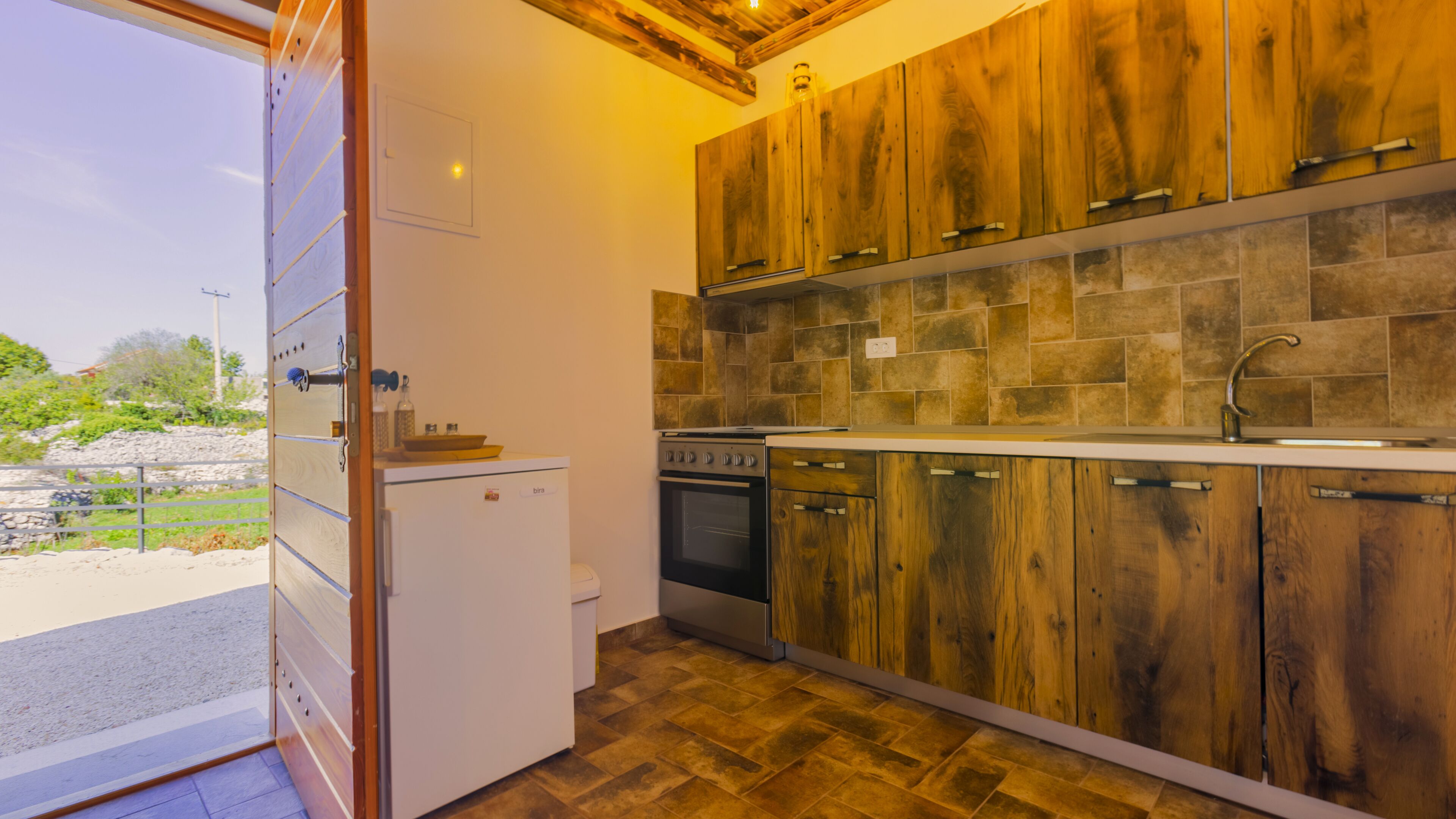 A modern kitchen with wooden cabinets, a built-in oven, and a sink.