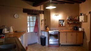 A kitchen with wooden cabinets, a stove, a sink, and a window.