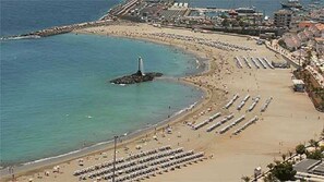 An aerial view of a beach with rows of sun loungers and a lighthouse. - Spring Apartment  (Costa del Silencio)