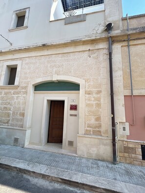 A building with a stone facade, a wooden door, and a small window.