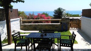 An outdoor patio with a table and chairs, a stone wall, and a view of the sea. -  House with sea views. Free WIFI. Punta Paloma, Tarifa (Tarifa)
