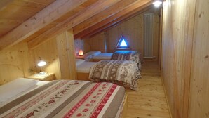 A wooden cabin with two beds, a nightstand, and a wall-mounted heater. - MASET POZZATTI MOUNTAIN CHALET (Baselga)