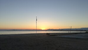 Une plage avec un mât et un banc.