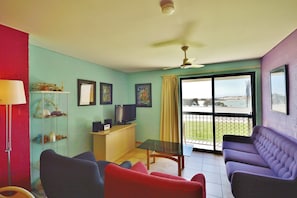 Relax in this stylish living room with a flat-screen TV, comfortable seating area, and beautiful views of the outdoors.