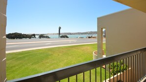 A balcony with a view of a road, grassy area, and a body of water. - Riverview Holiday Waterfront Apt 25 - 1st Floor - Kalbarri WA (Kalbarri)