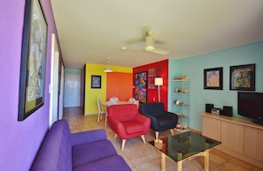 Relax in this stylish living room with a sofa, armchair, and coffee table, perfect for unwinding and enjoying the TV.