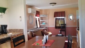 Un espace repas comprenant une table, des chaises et un ventilateur de plafond.