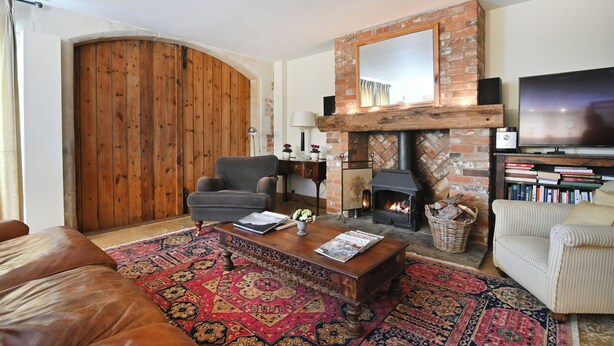 A living room with a fireplace, a television, a sofa, and a coffee table.