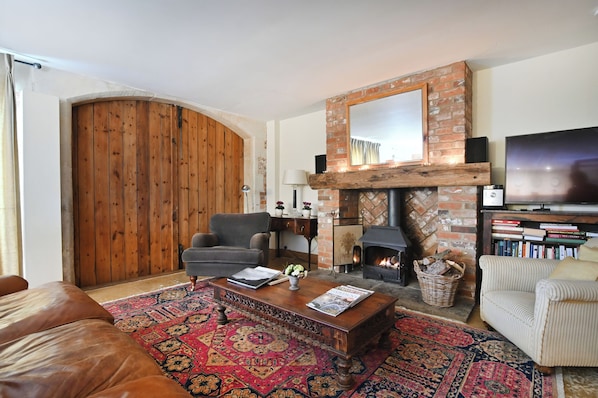 A living room with a fireplace, a television, a sofa, and a coffee table.