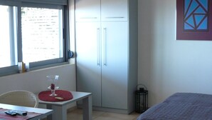 Una camera da letto con un letto, una scrivania con sedia, una finestra e un armadio.