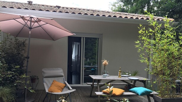 An outdoor patio with a table, chairs, and a large umbrella.