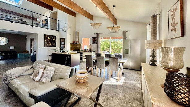 A spacious living area with a high ceiling, a dining table, and a kitchen in the background. - Villa PALOMA PISCINE Chauffée SPA between Narbonne and Béziers- 15 km VALRAS PLAGE (Colombiers)