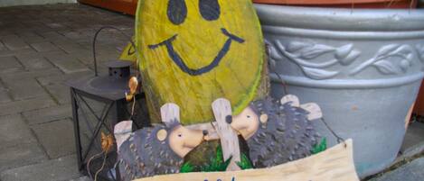 A welcome sign with a smiling face and a hedgehog decoration.