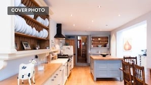 A spacious kitchen with wooden cabinets, a central island, and a dining area with wooden chairs.