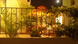 A nighttime view of a building with a balcony, surrounded by greenery and a fence. -   Sea  and Sun rise views. Villa with private pool and gated children Play Area. (paralimni)