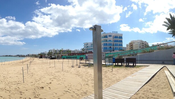 A beach with a wooden walkway and a pier. -   Sea  and Sun rise views. Villa with private pool and gated children Play Area. (paralimni)