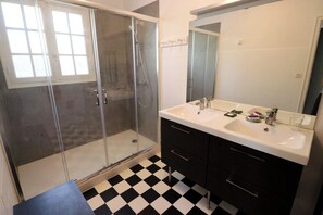 A bathroom with a glass-enclosed shower, a white sink, and a large mirror. - Lovely country house close beach A0384 (Cap Ferret / Piraillan)