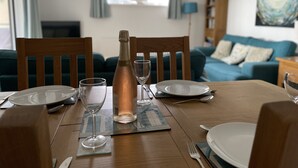 A dining table set with plates, cutlery, and a bottle of champagne. - Your holiday is just 100m from award winning beaches on Sandbanks peninsular. (Poole)