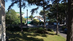 A residential area with houses, trees, and a clear sky. - Your holiday is just 100m from award winning beaches on Sandbanks peninsular. (Poole)