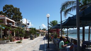Eine Küstenstraße mit Außenbereich, Steinpflaster und Blick auf das Meer.