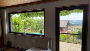 A bedroom with a bed, a radiator, a window, and a door leading to an outdoor area. - Adventure and Relaxation for you and your family in the Southern Bavarian Forest (Windorf)