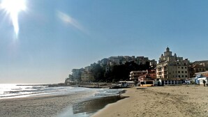 A beach with a row of buildings in the background. - Apartment With Large Terrazzo And Garden In Tranquil Village internet wifi (Costa Carnara)