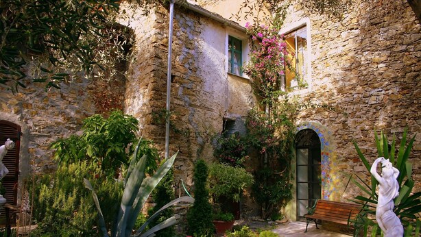 A stone building with a garden, a bench, and a statue. - Apartment With Large Terrazzo And Garden In Tranquil Village internet wifi (Costa Carnara)