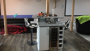 Une pièce moderne équipée d’une table de billard, d’un bar et de coins salon.