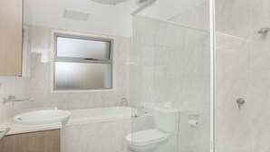 Un bagno moderno con vasca, servizi igienici e lavabo.
