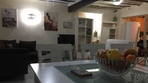 A living room with a white sofa, a glass coffee table with a bowl of fruit, and a painting on the wall. - TRADITIONAL SPANISH TOWN HOUSE INLAND SAX ALICANTE. SLEEPS 6 BED WIFI (sax)