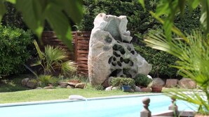 Une piscine avec une formation rocheuse en arrière-plan.