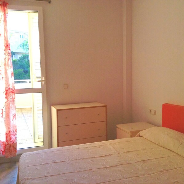 A bedroom with a bed, a dresser, and a nightstand.