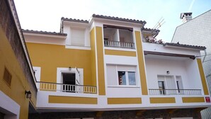 A two-story building with a yellow and white facade, stone base, and balconies with railings. - APARTMENT FOR 4 PEOPLE IN LIENCRES (Liencres)