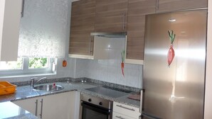 A modern kitchen with granite countertops, stainless steel appliances, and wooden cabinets. - APARTMENT FOR 4 PEOPLE IN LIENCRES (Liencres)