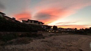 A coastal landscape with buildings and a sunset. - Maison "The Little Gate", seaside paradise. (porto san paolo)